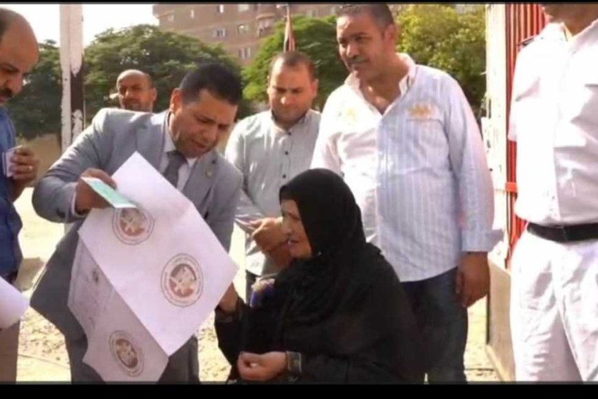 قاضٍ يساعد سيدة مسنة على الإدلاء بصوتها في انتخابات مجلس الشيوخ بالقاهرة